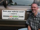 U-C WEBS' Nardo Kuitert besides car with sticker "Does Your Website Suck? (...people in)"